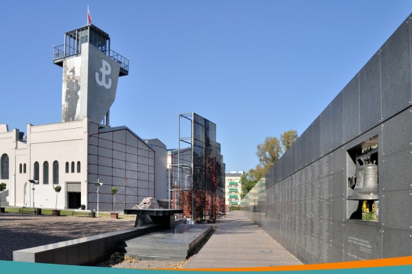 Warsaw Uprising Museum exterior with the memorial wall and observation tower displaying the Kotwica resistance symbol